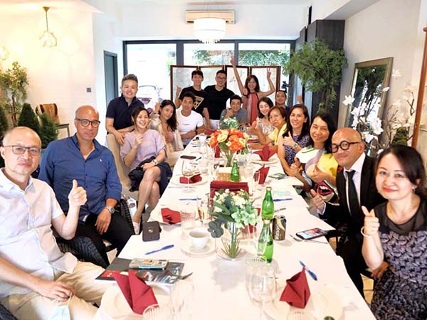 Group of people sitting around a long dinner table