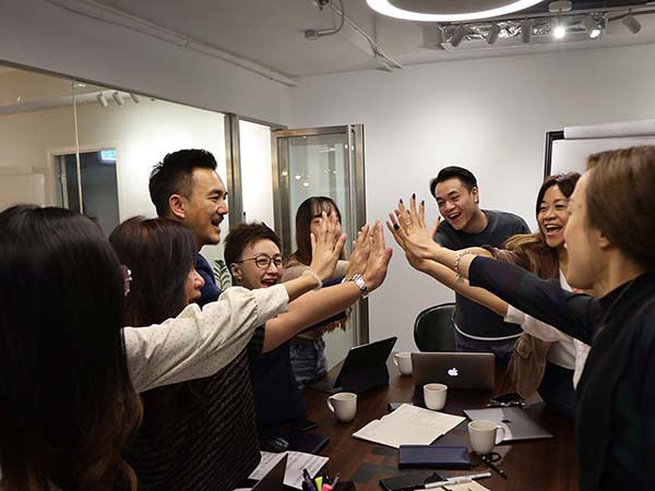 Group of people raised hands high fiving